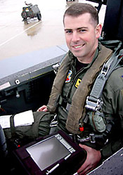 A U.S. Air Force weapon systems officer displays the tablet PC used aboard an F-15 strike fighter.